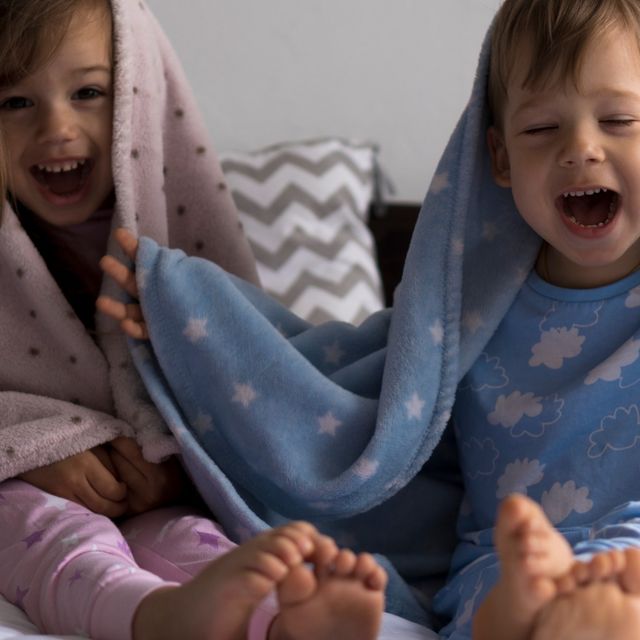 niños en cama y pijama